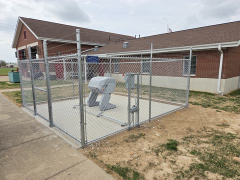 Galvanized chain-link enclosure around equipment at a commercial building in Northwest Arkansas