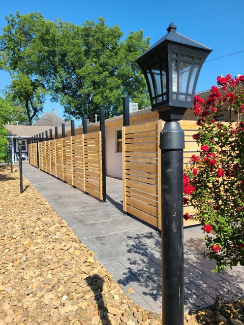 Modern cedar-slat fence and lamp post built by the next generation of the family in Northwest Arkansas