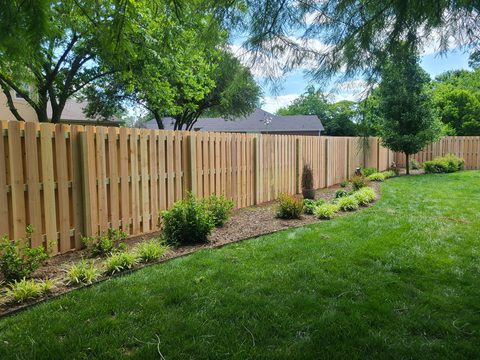 Cedar shadowbox privacy fence with fresh landscaping in Northwest Arkansas