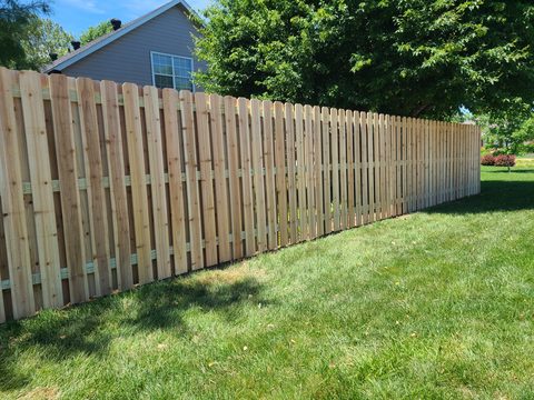 Cedar shadowbox privacy fence running beside a home in Northwest Arkansas